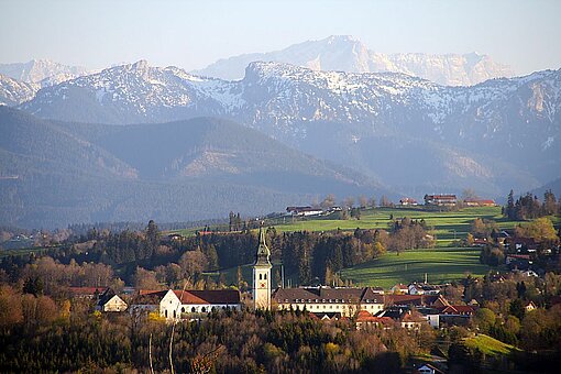 Blick auf das ehemalige Kloster in Rottenbuch mit den Alpen im Hintergrund.