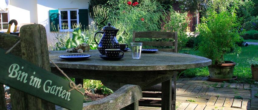 Gedeckter Tisch im Garten lädt zum Kaffee trinken ein.